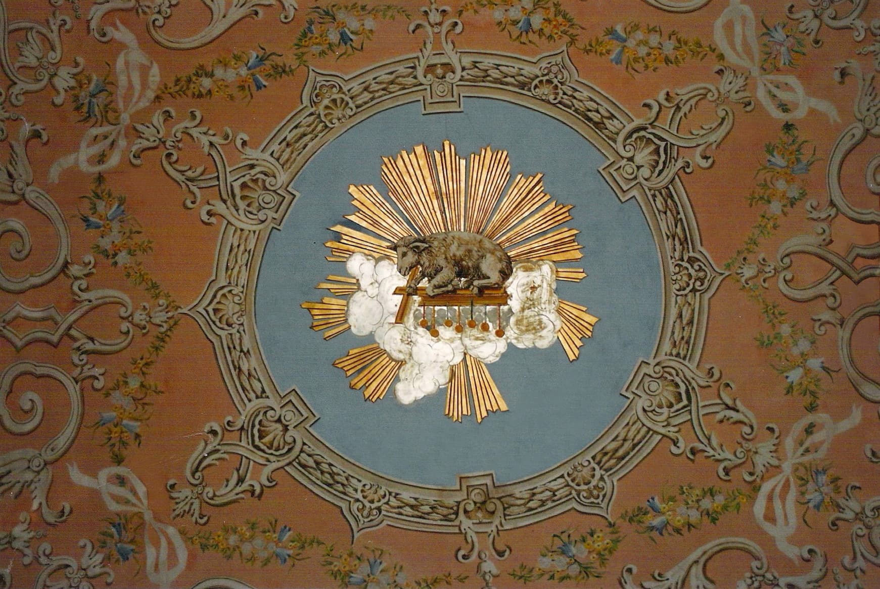 Ornate classical fresco with lamb in medallion, floral garlands on peach background