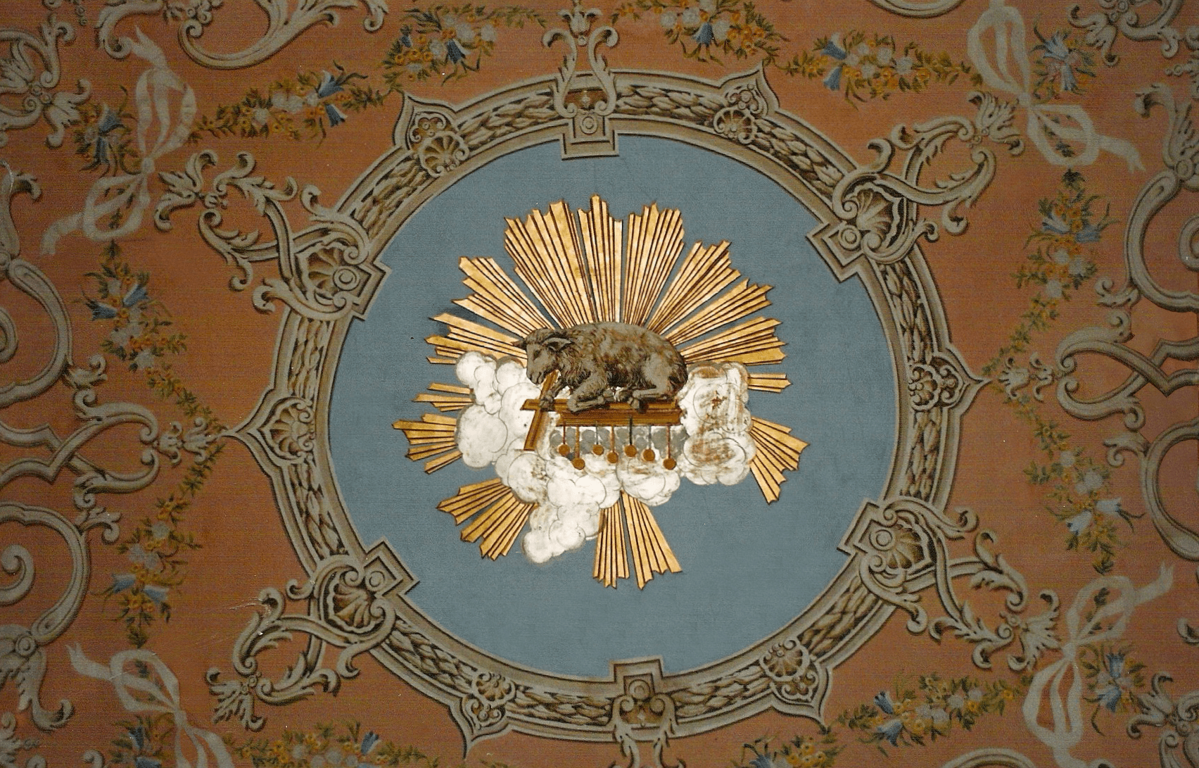 Ornate classical fresco with lamb in medallion, floral garlands on peach background