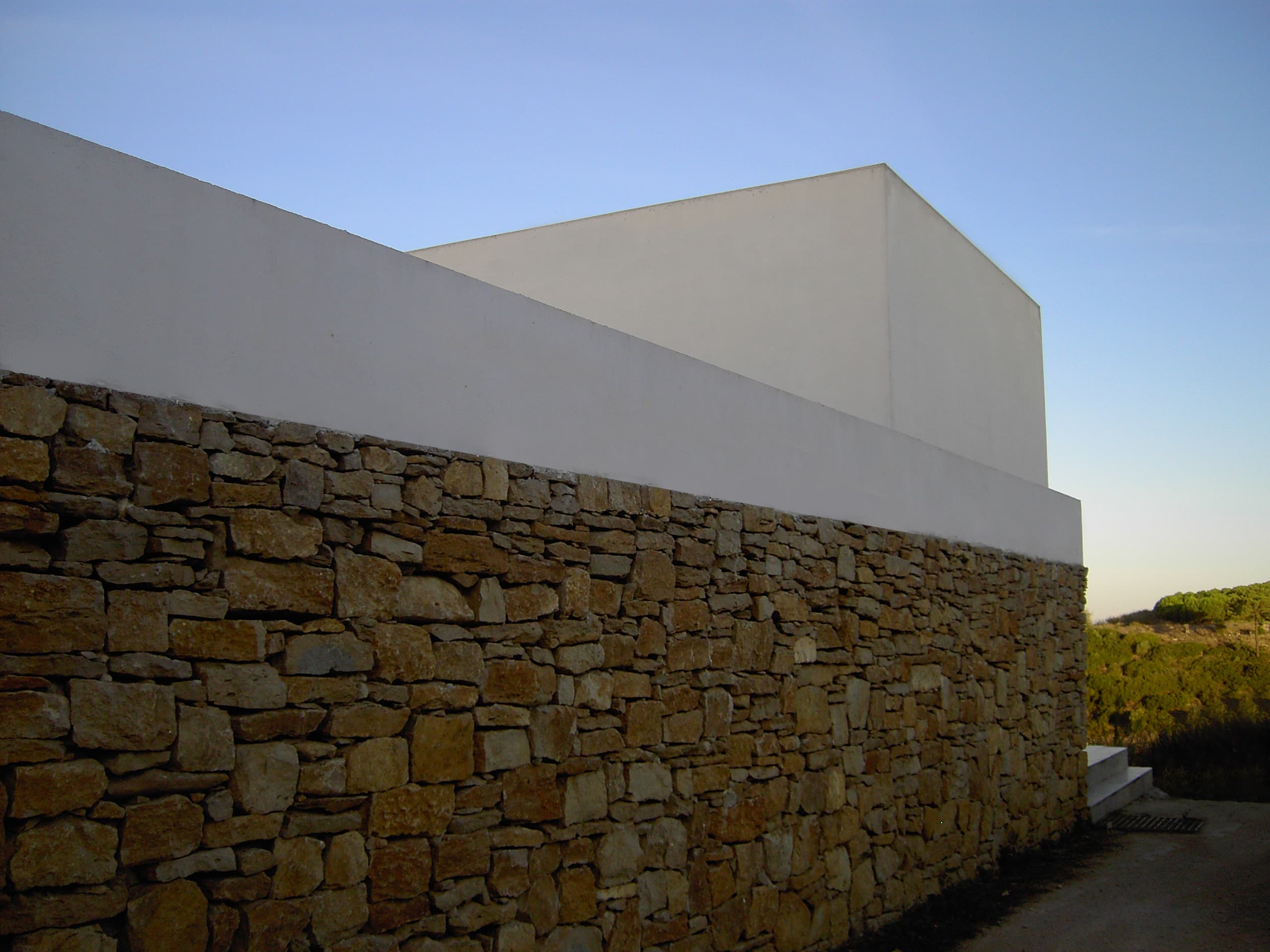 Modern building with natural stone base and white minimalist walls